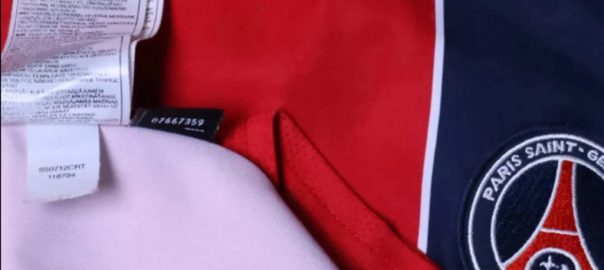 Binnenkant van een PSG Nike-shirt met labels en opdruk voor uitleg over onderhoud en wassen.